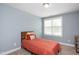 Bedroom with neutral carpet, light blue walls and a full size bed. Large window provides natural light at 14 E Saddle Ct, Archer Lodge, NC 27527