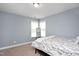 Bedroom with neutral carpet, light blue walls and a full size bed with a mirror at 14 E Saddle Ct, Archer Lodge, NC 27527