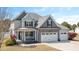 Charming two-story home with gray siding, stone accents, and a well-manicured lawn at 14 E Saddle Ct, Archer Lodge, NC 27527