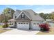 Two-story home featuring gray siding, stone accents, attached garage, and professionally landscaped yard at 14 E Saddle Ct, Archer Lodge, NC 27527