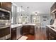 Bright kitchen features dark cabinets, pendant lights, quartz countertops and stainless steel appliances at 14 E Saddle Ct, Archer Lodge, NC 27527