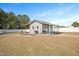 This outbuilding features light gray siding, a covered patio, and a garden with a white vinyl fence at 14 E Saddle Ct, Archer Lodge, NC 27527