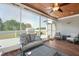 Covered sunroom with ceiling fan, outdoor view and comfortable gray seating at 14 E Saddle Ct, Archer Lodge, NC 27527