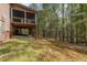 Exterior view of the home, showcasing a back patio leading to a wooded backyard area at 1409 Turner Farms Rd, Garner, NC 27529