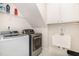 Bright laundry room with washer, dryer, utility sink, white cabinets, and ample storage space at 1409 Turner Farms Rd, Garner, NC 27529