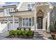 A charming covered front porch with stone steps, decorative flower pots, a black front door, and gray siding at 142 Old Piedmont Cir, Chapel Hill, NC 27516