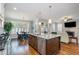 A bright and spacious kitchen with an island featuring granite countertops, a stainless steel dishwasher, and hardwood floors at 142 Old Piedmont Cir, Chapel Hill, NC 27516