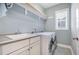 Laundry room featuring a modern washer and dryer, utility sink and a window for natural light at 142 Old Piedmont Cir, Chapel Hill, NC 27516