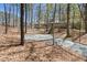 Exterior view of a lovely home nestled among mature hardwood trees and a circular driveway at 1516 Cumberland Rd, Chapel Hill, NC 27514