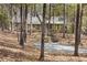 Exterior view of a lovely home nestled among mature hardwood trees in a wooded landscape at 1516 Cumberland Rd, Chapel Hill, NC 27514
