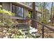 Close-up of home's entrance featuring vibrant green door, stone steps, and mature landscaping at 1516 Cumberland Rd, Chapel Hill, NC 27514