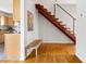 Hallway featuring a red modern staircase, wooden floors, and decorative bench at 1516 Cumberland Rd, Chapel Hill, NC 27514