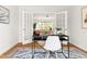 Modern home office featuring a sleek black desk, white chair, and views into the living room at 1516 Cumberland Rd, Chapel Hill, NC 27514