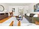 Spacious living room with hardwood floors, stylish seating, and a glimpse into an adjacent room at 1516 Cumberland Rd, Chapel Hill, NC 27514