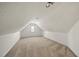 Bright attic space with neutral carpet, a small window, and textured ceilings at 155 Chimney Rise Dr, Cary, NC 27511
