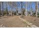 Picturesque backyard featuring a stone path that leads to a waterfront view surrounded by tall trees at 155 Chimney Rise Dr, Cary, NC 27511