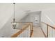 Hallway with carpeted floors, white walls, wood railings, and a modern chandelier at 155 Chimney Rise Dr, Cary, NC 27511