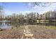 A peaceful lake with stone steps leading down to the water, surrounded by mature trees at 155 Chimney Rise Dr, Cary, NC 27511