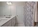 Bright bathroom featuring double sinks, a shower with curtain, and modern fixtures at 16 Blue Monarch Ln, Fuquay Varina, NC 27526