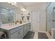 Elegant bathroom featuring double sinks, walk-in glass shower, and modern lighting fixtures at 16 Blue Monarch Ln, Fuquay Varina, NC 27526