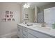 Bright bathroom featuring double sinks, a large mirror, and decorative Gathering photos on the wall at 16 Blue Monarch Ln, Fuquay Varina, NC 27526