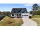Two-story home with a manicured lawn, attached garage, welcoming front porch, and beautiful landscaping at 16 Blue Monarch Ln, Fuquay Varina, NC 27526