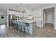 Bright kitchen boasts white cabinetry, a center island with pendant lighting, and stainless steel appliances at 16 Blue Monarch Ln, Fuquay Varina, NC 27526