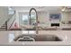 Modern kitchen sink overlooking a cozy living area with a fireplace and staircase, providing a warm, inviting feel at 16 Blue Monarch Ln, Fuquay Varina, NC 27526