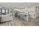 Modern kitchen featuring white cabinets, a stainless steel refrigerator, and a stylish island with bar stool seating at 16 Blue Monarch Ln, Fuquay Varina, NC 27526