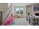 Cozy living space adjacent to the stairs with large windows and a decorative fireplace at 16 Blue Monarch Ln, Fuquay Varina, NC 27526