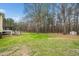 Home's exterior and back yard featuring mature trees and lawn at 1638 Crystal Ln, Stem, NC 27581