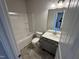 Bathroom featuring a tub, vanity with sink, gray tile flooring and access to another room at 168 Bruce Dr, Dunn, NC 28334