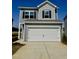 Two-story home with gray siding, black shutters, and a white garage door under a blue sky at 168 Bruce Dr, Dunn, NC 28334