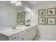 Bright bathroom featuring marble-style floor, white cabinets, and a decorative mirror at 176 Bruce Dr, Dunn, NC 28334