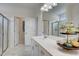 Bright bathroom featuring marble-style floor and shower and white cabinets at 176 Bruce Dr, Dunn, NC 28334