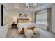Bright main bedroom with neutral walls, tray ceiling, chandelier, and seating area at 176 Bruce Dr, Dunn, NC 28334