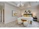 Bright main bedroom featuring a tray ceiling, chandelier, and seating area at 176 Bruce Dr, Dunn, NC 28334