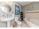 Bathroom featuring a jacuzzi tub and a pedestal sink with decorative soap and lotion dispensers at 211 W Chisholm St, Sanford, NC 27330