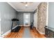 Exercise room with a treadmill, weights, golf clubs, stone wall paneling, and hardwood floors at 211 W Chisholm St, Sanford, NC 27330