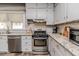 Kitchen features stainless appliances, granite counters and bright white cabinetry at 211 W Chisholm St, Sanford, NC 27330