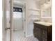 Bathroom featuring dark vanity, shelves, decorative mirror, and a toilet room with black and white tile at 227 Coley Farm Rd, Fuquay Varina, NC 27526