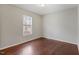This bedroom features hardwood floors, a window letting in natural light, and neutral colored walls at 227 Coley Farm Rd, Fuquay Varina, NC 27526