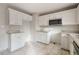 Kitchen featuring light tile floors, white cabinets, stainless steel microwave and granite countertops at 227 Coley Farm Rd, Fuquay Varina, NC 27526