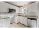 Kitchen featuring light tile floors, white cabinets, stainless steel dishwasher and granite countertops at 227 Coley Farm Rd, Fuquay Varina, NC 27526