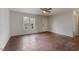 A light-filled living room with hardwood floors, a ceiling fan, and a pair of large windows at 227 Coley Farm Rd, Fuquay Varina, NC 27526