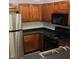 Well-maintained kitchen featuring wood cabinets, black appliances, and sleek countertops in a cozy layout at 2631 Oldgate Dr # 101, Raleigh, NC 27604
