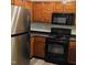 Close-up of a kitchen with stainless steel refrigerator, range, microwave, and dark countertop at 2631 Oldgate Dr # 101, Raleigh, NC 27604