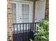 Small patio with black iron railing, featuring double doors and greenery at 2631 Oldgate Dr # 101, Raleigh, NC 27604