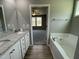 Bathroom featuring a tub, double vanity with granite countertop, and modern fixtures at 279 Constellation Ct, Benson, NC 27504