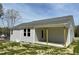 Well-maintained home featuring a covered patio, grey siding, and a neatly manicured lawn at 279 Constellation Ct, Benson, NC 27504
